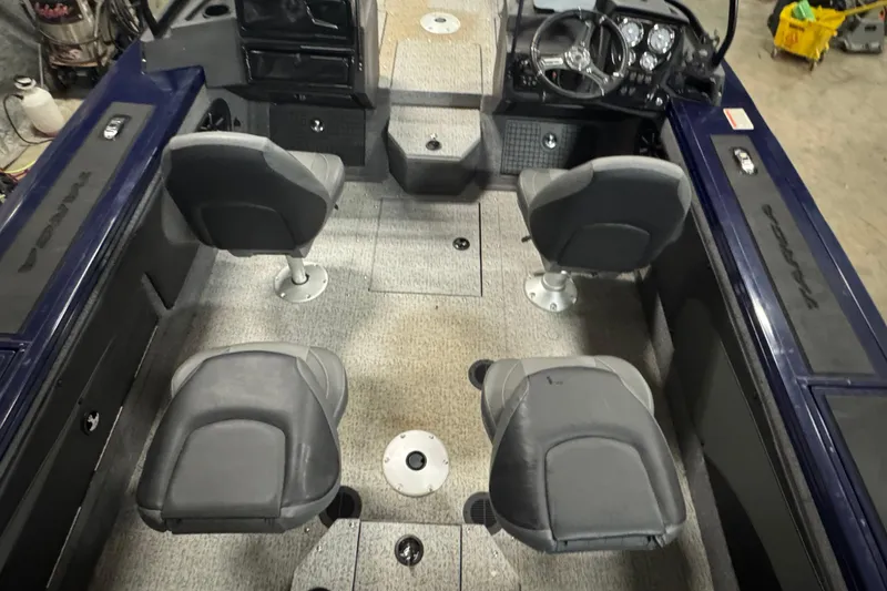 Slide: The Image of 2024 Tracker Targa V-19 Combo boat interior with four seats and control panel. - 24