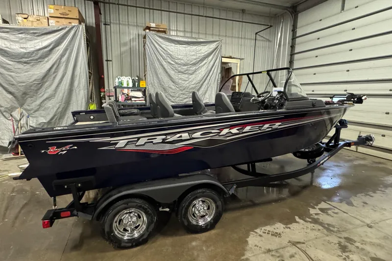 Slide: The Image of 2024 Tracker Targa V-19 Combo boat with powerful outboard motor in a garage setting. - 3