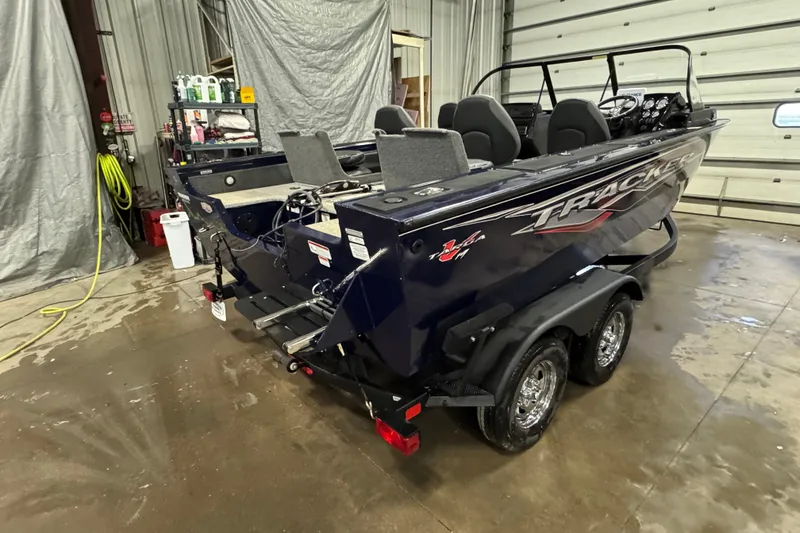 Slide: The Image of 2024 Tracker Targa V-19 Combo boat in a garage, featuring a powerful outboard motor. - 4