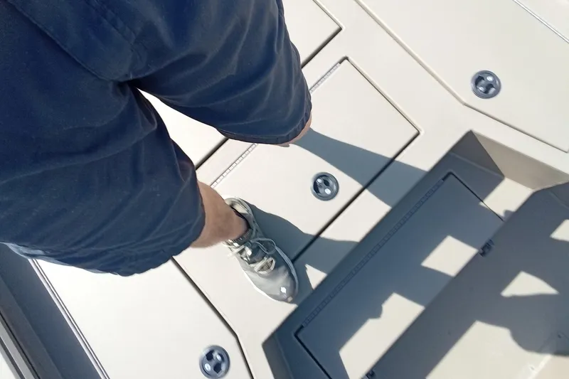 Slide: The Image of Person standing on Thor 1900 Lake Hammer boat deck, wearing shorts and sneakers. - 18