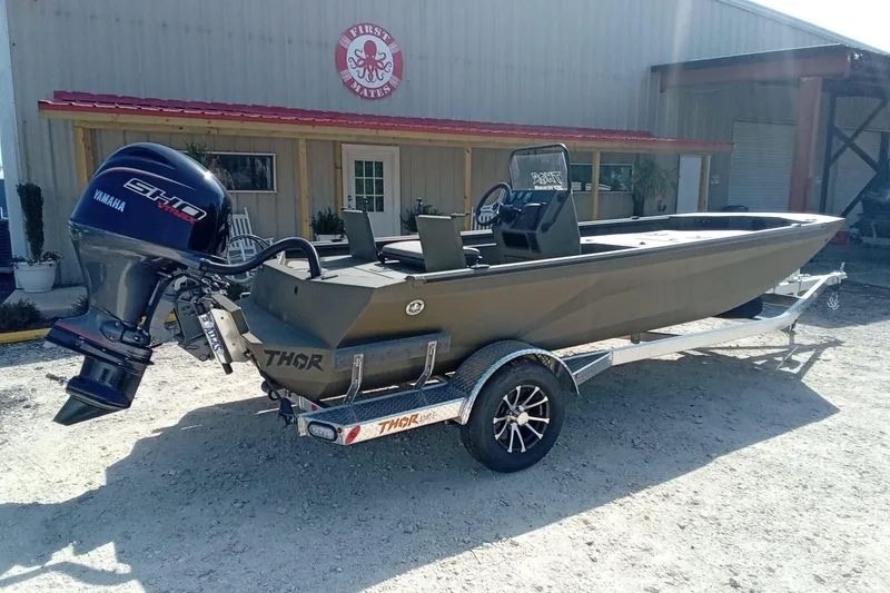 Slide: The Image of 2025 Thor 1900 Lake Hammer boat on trailer with Yamaha engine, parked outside a building. - 3