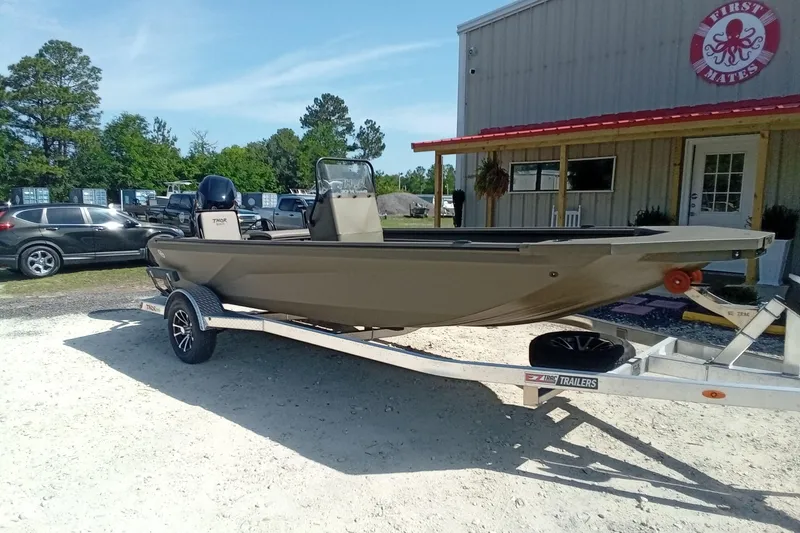 Slide: The Image of 2025 Thor 1900 Lake Hammer boat on trailer outside a building, sunny day. - 4