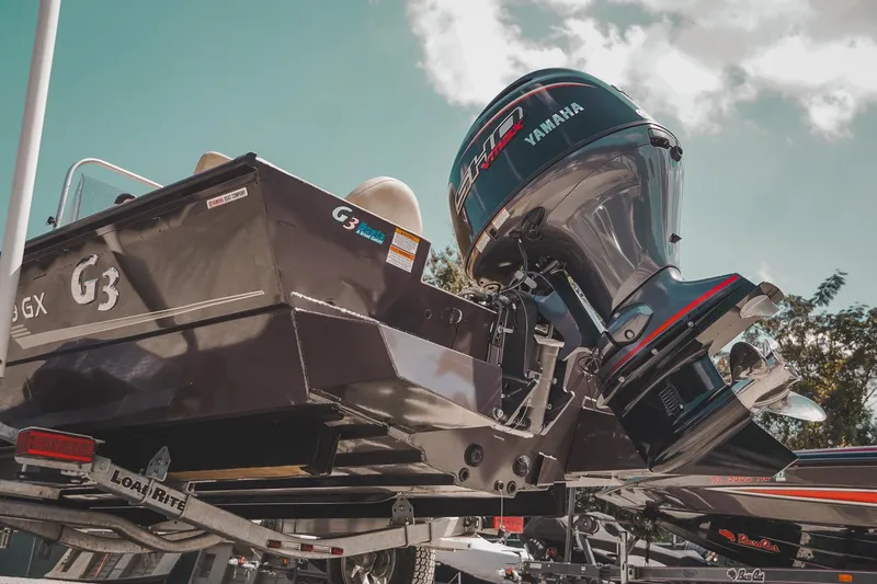 Slide: The Image of 2025 G3 Bay 19 GX boat with Yamaha engine on trailer under clear sky. - 24