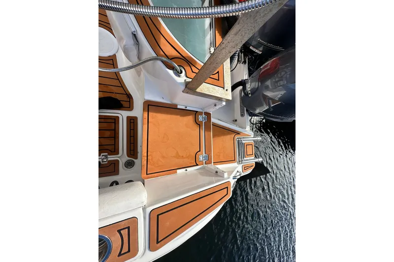 Slide: The Image of 2016 Sea Fox 256 Voyager boat deck with wood accents and outboard motor. - 3