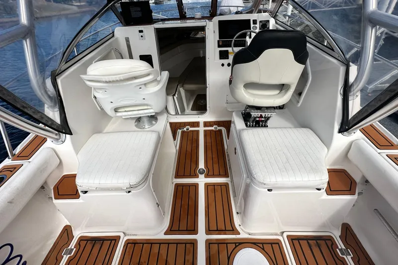 Slide: The Image of Interior of a 2016 Sea Fox 256 Voyager boat with white seating and wood accents. - 5