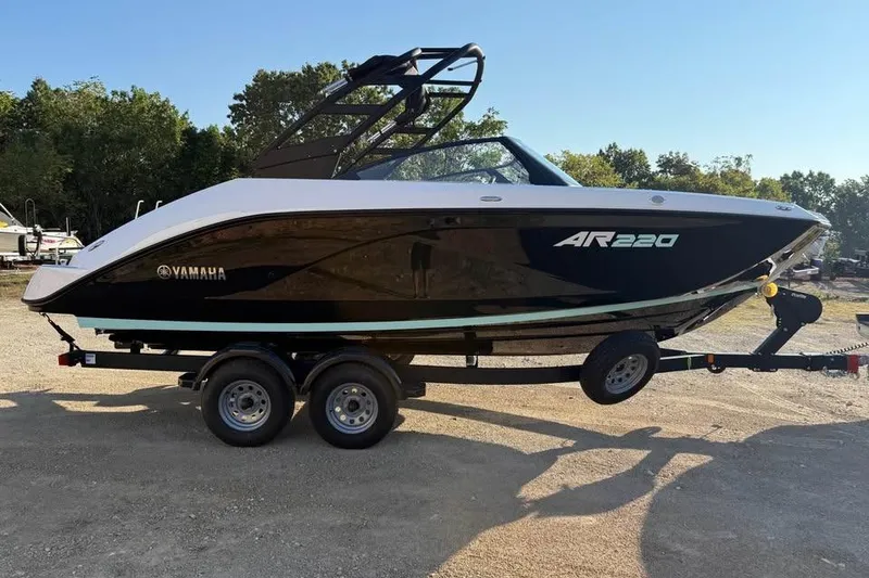 Slide: The Image of 2026 Yamaha Boats AR220 on trailer, sleek black design, parked outdoors. - 4