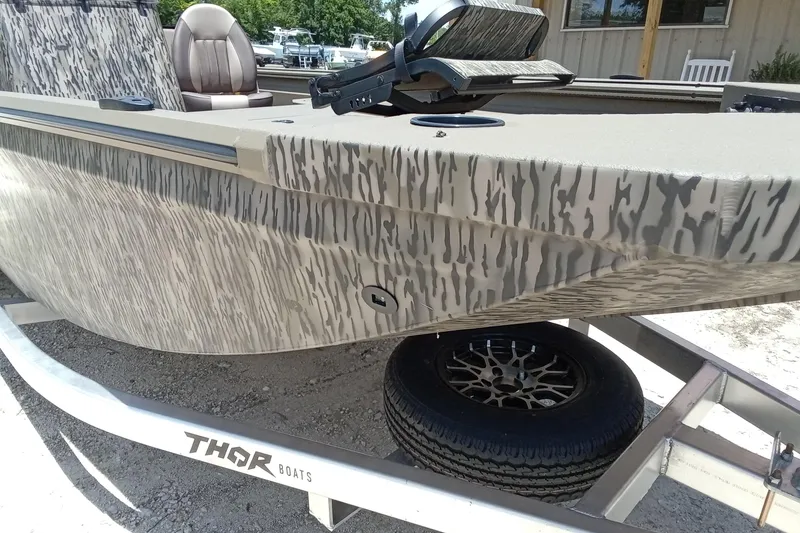 Slide: The Image of 2026 Thor 1900 Lake Hammer SC boat with camouflage design on a trailer. - 7