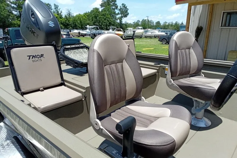 Slide: The Image of 2026 Thor 1900 Lake Hammer SC boat interior with comfortable seating and Suzuki outboard motor. - 11