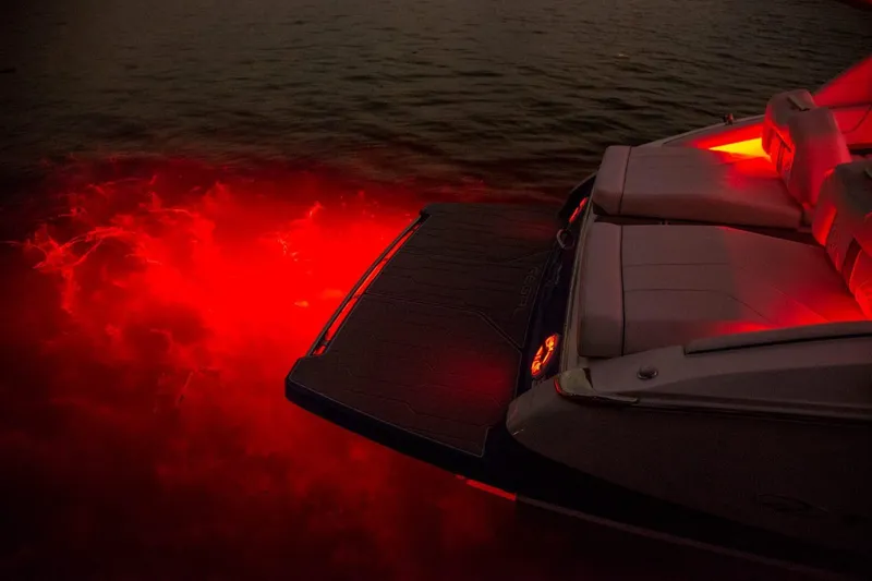 Slide: The Image of 2026 Regal LS9 boat with red underwater lights illuminating the water at night. - 4