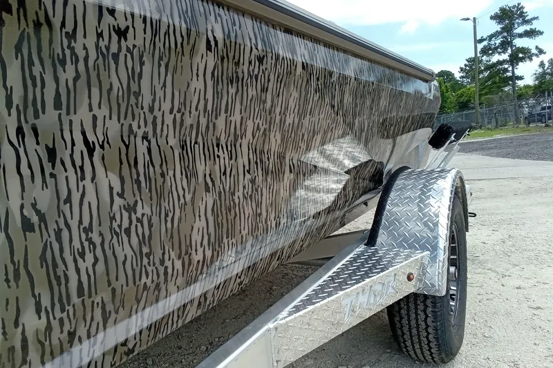 Slide: The Image of 2026 Thor 1754 Timber Hammer boat with camouflage design on a trailer. - 4