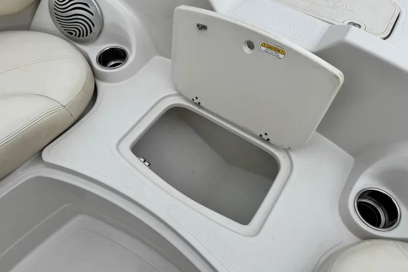Slide: The Image of 2014 Tahoe 215 boat interior with open storage compartment and cup holders. - 16