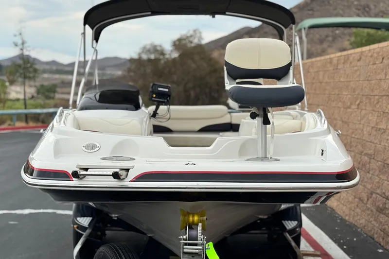 Slide: The Image of 2014 Tahoe 215 boat with seating, parked on a trailer, scenic background. - 2
