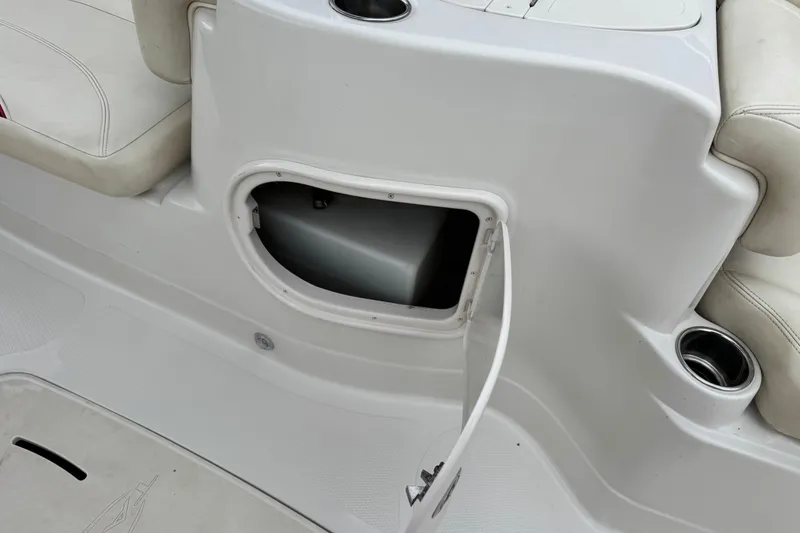 Slide: The Image of 2014 Tahoe 215 boat interior storage compartment with open hatch and cup holder. - 21