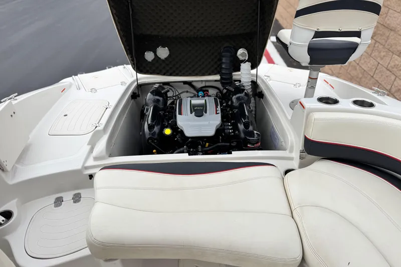 Slide: The Image of 2014 Tahoe 215 boat engine compartment with seating and cup holders. - 23