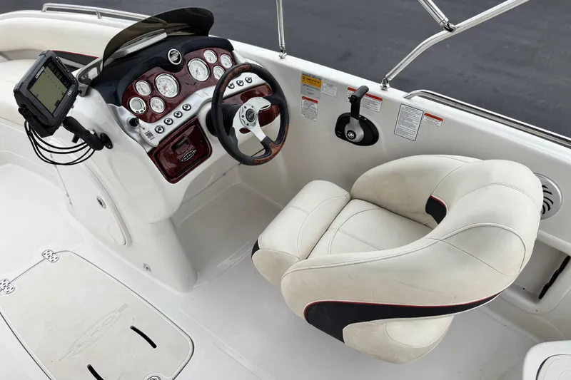 Slide: The Image of 2014 Tahoe 215 boat cockpit with steering wheel, gauges, and cushioned captain's chair. - 27