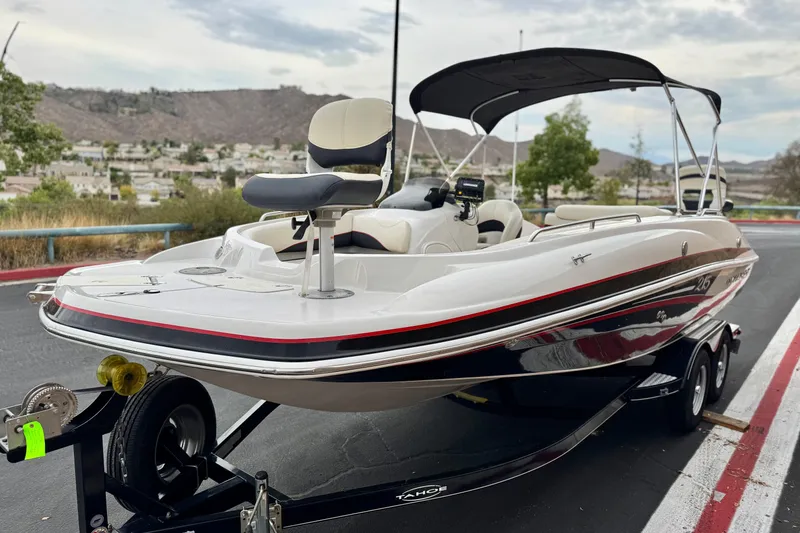 Slide: The Image of 2014 Tahoe 215 boat on trailer, parked with scenic mountain backdrop. - 3