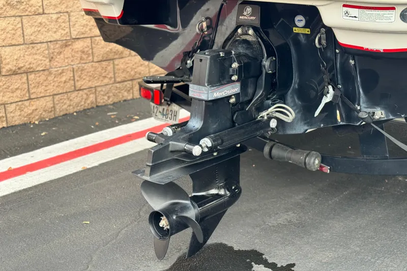 Slide: The Image of 2014 Tahoe 215 boat with MerCruiser outdrive, parked on asphalt near brick wall. - 9