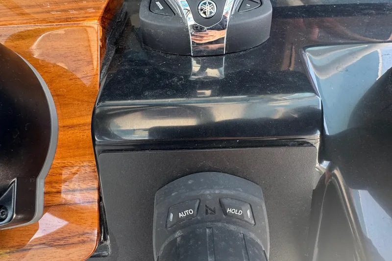 Slide: The Image of 2026 Robalo R300 Center Console boat controls with wood and black finish. - 21