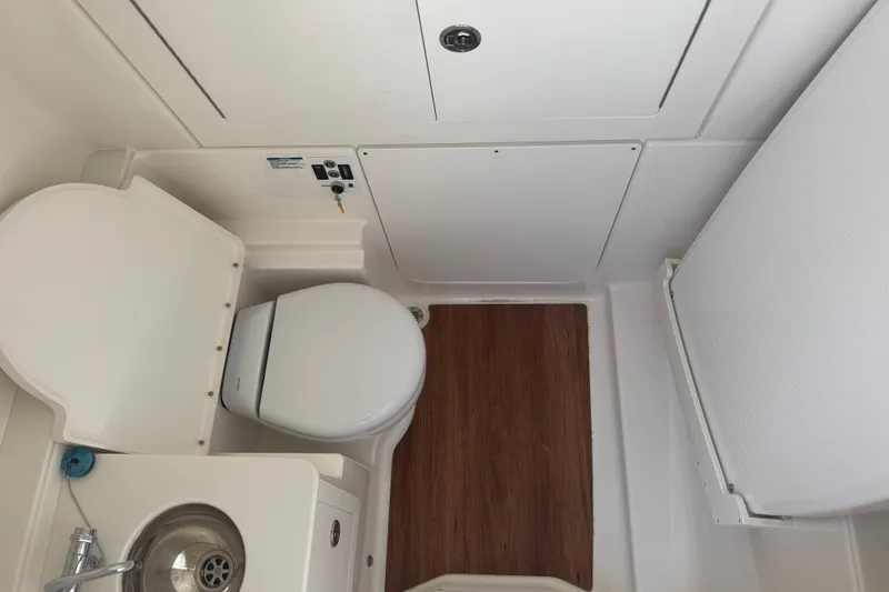 Slide: The Image of 2026 Robalo R300 Center Console boat bathroom with toilet and sink. - 29