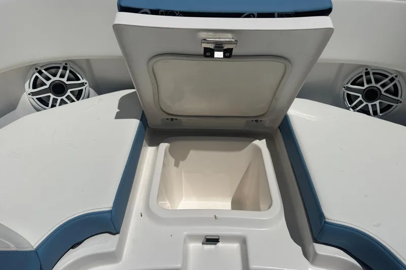 Slide: The Image of 2026 Robalo R300 Center Console boat storage compartment with open lid and speakers. - 37