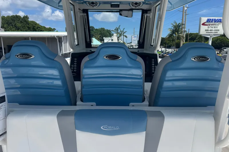 Slide: The Image of 2026 Robalo R300 Center Console boat with blue seating and modern dashboard. - 8