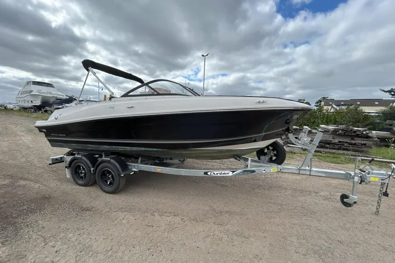 Slide: The Image of 2021 Bayliner VR4 Bowrider OB on trailer, parked outdoors under cloudy sky. - 11