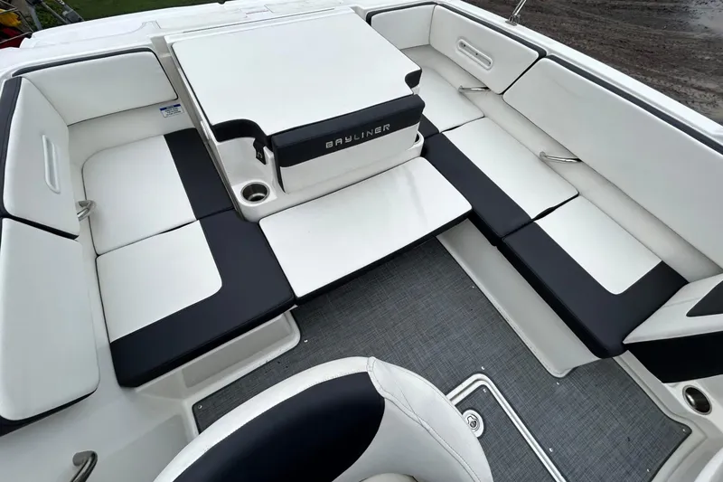 Slide: The Image of 2021 Bayliner VR4 Bowrider OB interior with white and black seating, cup holders, and spacious layout. - 6