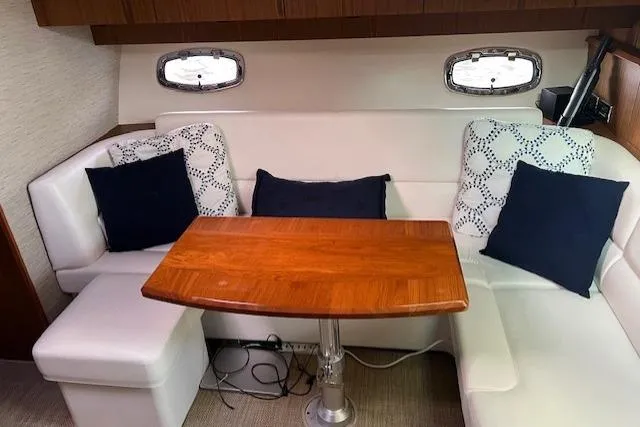 Slide: The Image of Interior of 2014 Tiara Yachts 3900 Coronet with white seating and wooden table. - 18