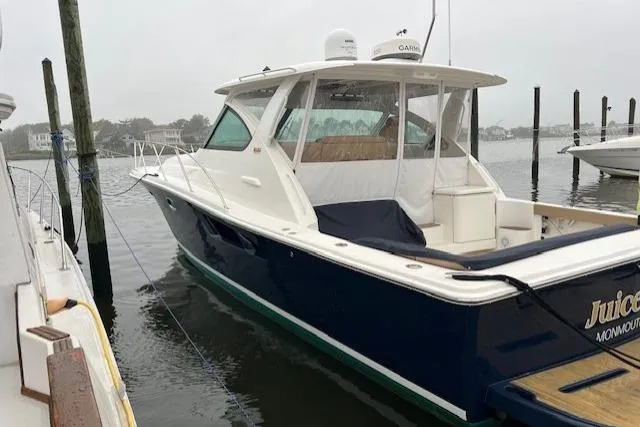 Slide: The Image of 2014 Tiara Yachts 3900 Coronet docked in a marina on a cloudy day. - 2