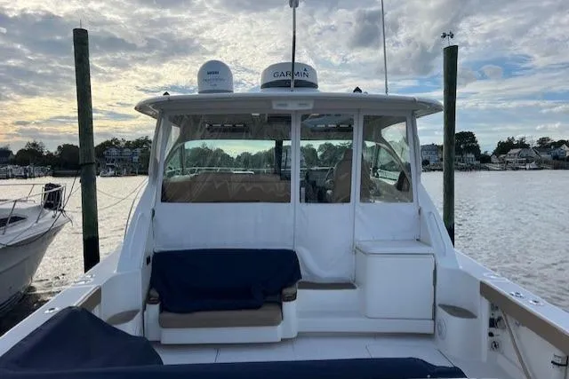 Slide: The Image of 2014 Tiara Yachts 3900 Coronet docked, showcasing spacious deck and seating area. - 29