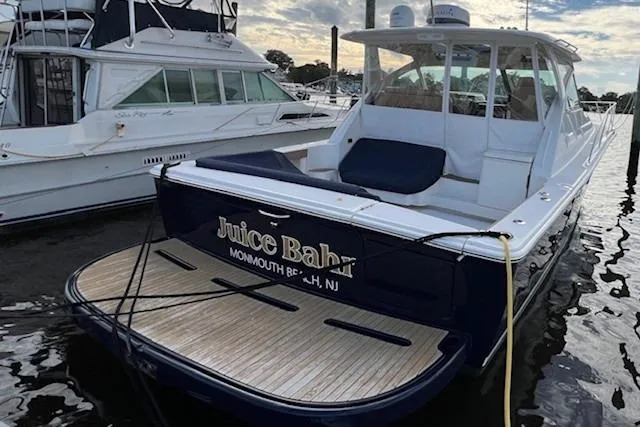 Slide: The Image of 2014 Tiara Yachts 3900 Coronet docked, featuring spacious deck and sleek design. - 6