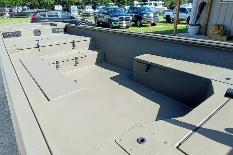 Slide: The Image of 2026 Thor 1754 Timber Hammer boat interior with storage compartments, parked cars in background. - 12