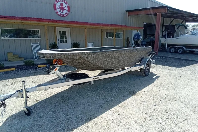 Slide: The Image of 2026 Thor 1754 Timber Hammer boat on trailer outside a building. - 3