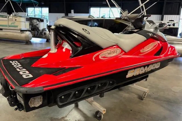 Slide: The Image of 2005 Sea-Doo Wake 155 jet ski in vibrant red and black, displayed indoors. - 11