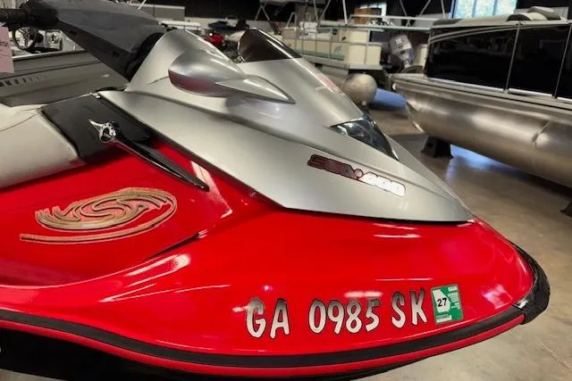 Slide: The Image of 2005 Sea-Doo Wake 155 jet ski, red and silver, displayed indoors. - 14