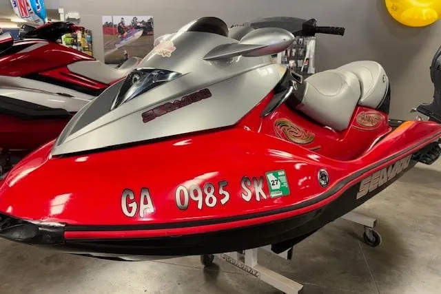 Slide: The Image of 2005 Sea-Doo Wake 155 jet ski in showroom, red and silver design. - 3