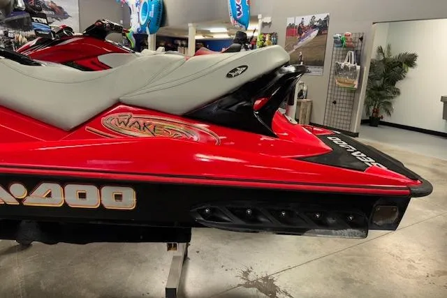 Slide: The Image of 2005 Sea-Doo Wake 155 jet ski, red and black, displayed indoors. - 5