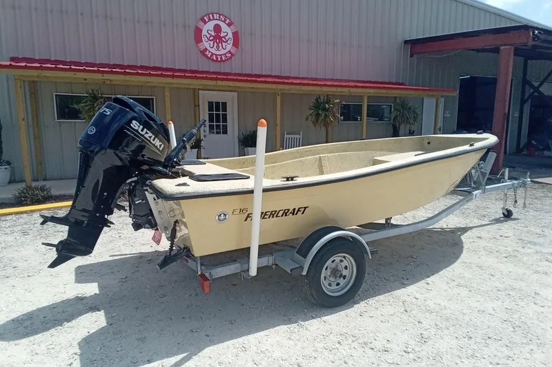 Slide: The Image of 2025 Fibercraft F16 boat with Suzuki engine on trailer outside a building. - 4