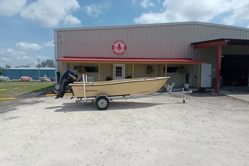 Slide: The Image of Fibercraft F16 boat, 2025 model, parked outside a warehouse on a sunny day. - 6