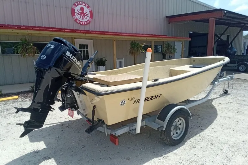 Slide: The Image of 2025 Fibercraft F16 boat with Suzuki engine on trailer outside a building. - 8