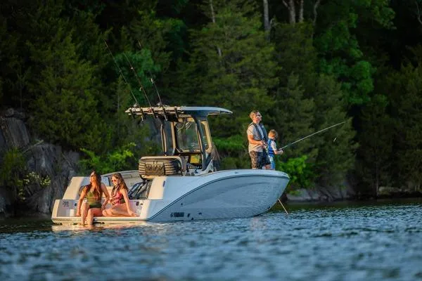 Slide: The Image of 2026 Yamaha Boats 255 FSH Sport H on a serene lake with people fishing. - 10
