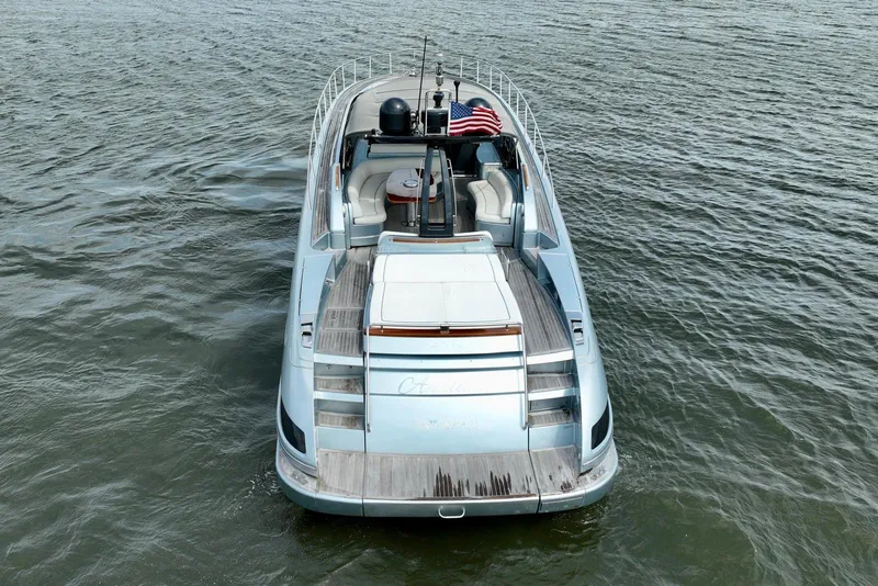 Slide: The Image of 2016 Riva 63 Virtus luxury yacht on open water, rear view with American flag. - 16