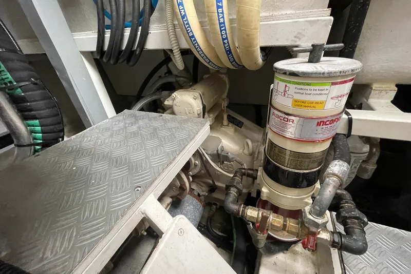 Slide: The Image of Engine room of 2016 Riva 63 Virtus yacht, featuring mechanical components and hoses. - 59