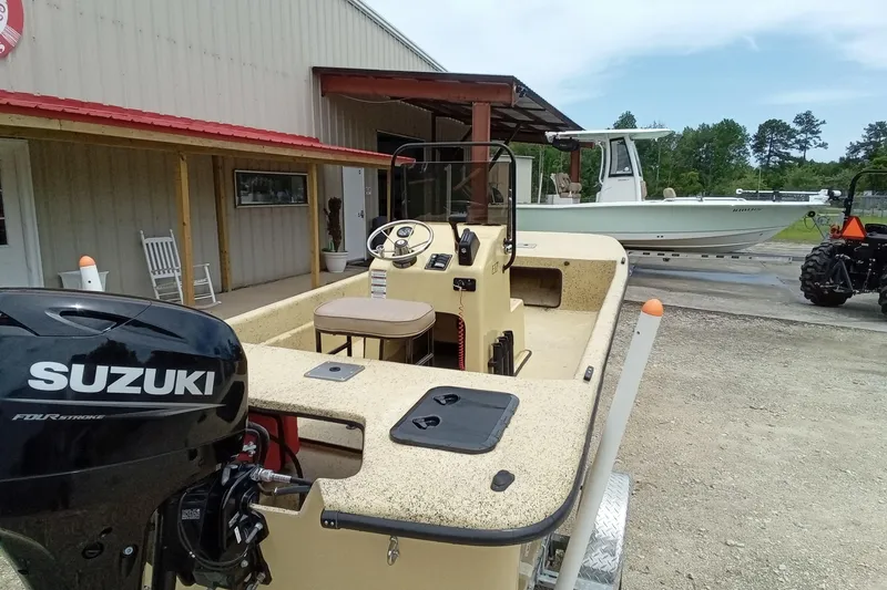 Slide: The Image of 2025 Fibercraft F17 boat with Suzuki engine, parked near a building and tractor. - 15