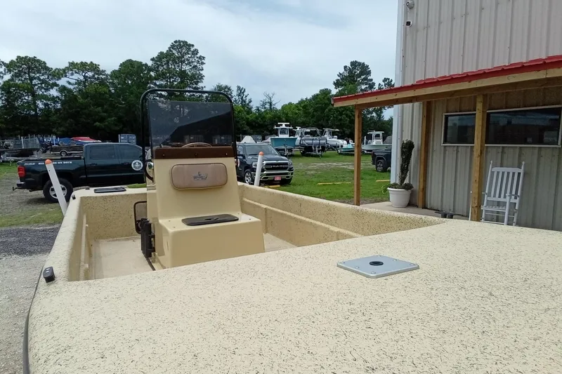 Slide: The Image of 2025 Fibercraft F17 boat parked outside a building, surrounded by vehicles and trees. - 5