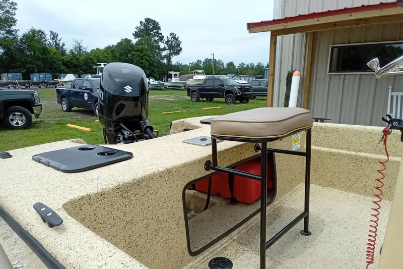 Slide: The Image of 2025 Fibercraft F17 boat with Suzuki outboard motor, parked outdoors near a building. - 9