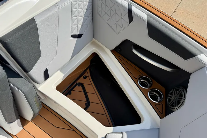 Slide: The Image of 2026 Nautique Super Air Nautique GS20 interior with storage, cup holders, and speaker. - 24