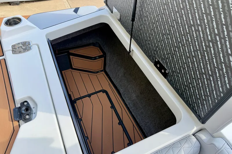 Slide: The Image of 2026 Nautique Super Air Nautique GS20 storage compartment with open lid and detailed interior design. - 32