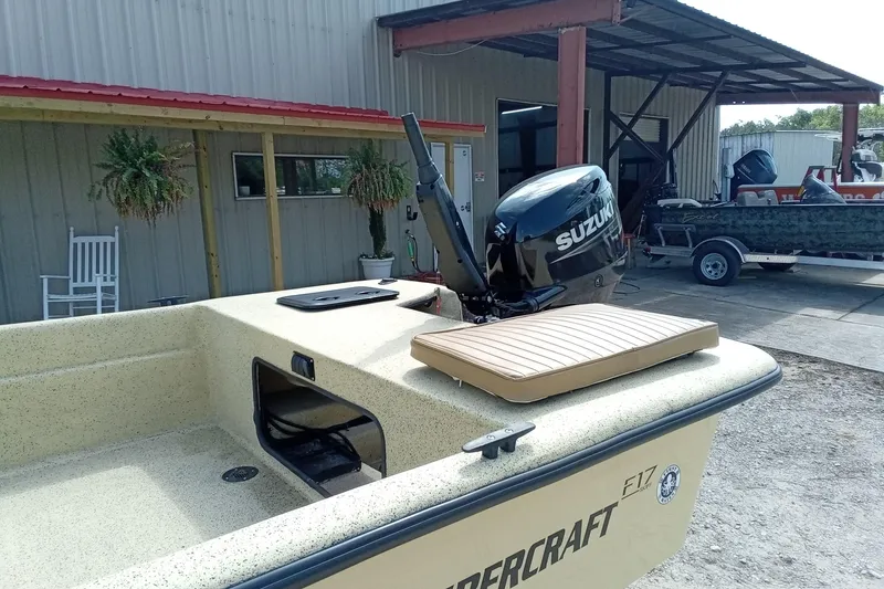 Slide: The Image of Fibercraft F17 boat with Suzuki motor, parked near a metal building, 2025 model. - 10