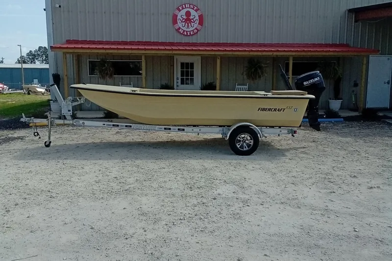 Slide: The Image of 2025 Fibercraft F17 boat on trailer outside a building with red roof. - 13